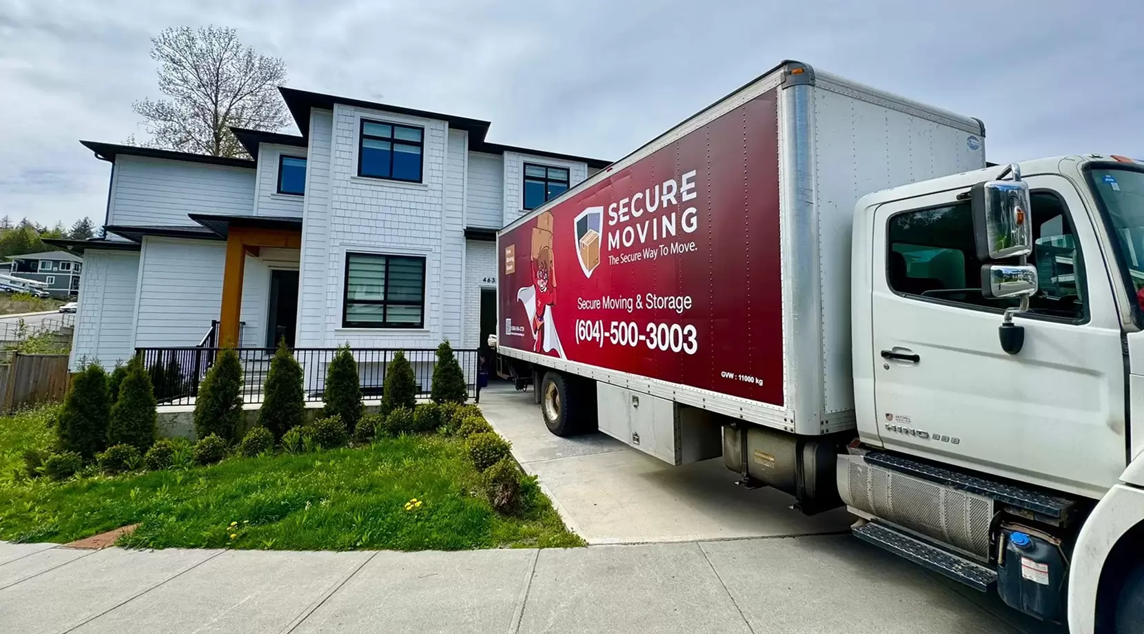Secure Moving truck backed into the driveway of a home.