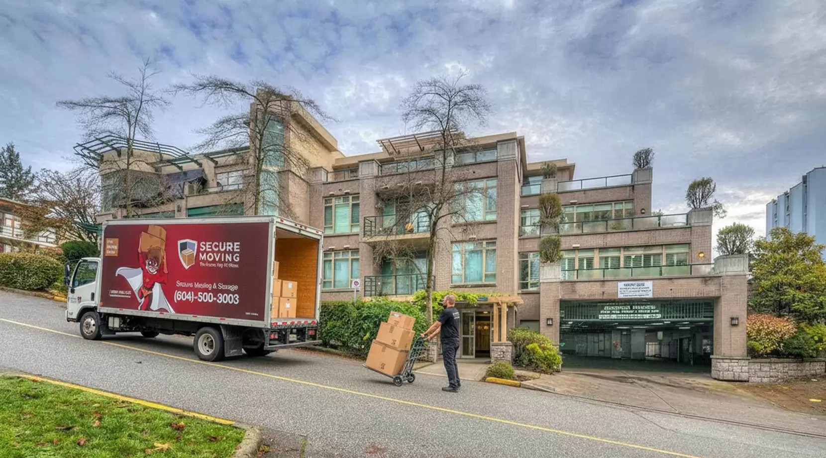 Secure Moving truck unloading boxes at a condo entrance on a sloped street, reflecting West Vancouver neighbourhood safety and smooth moving day.
